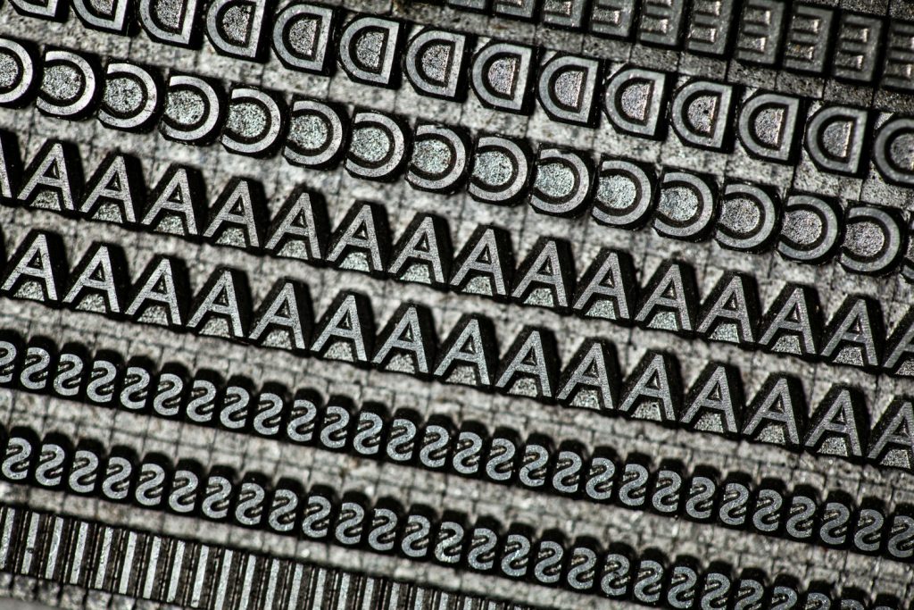 Close-up of metal letterpress type showing rows of letters D, A, and S.