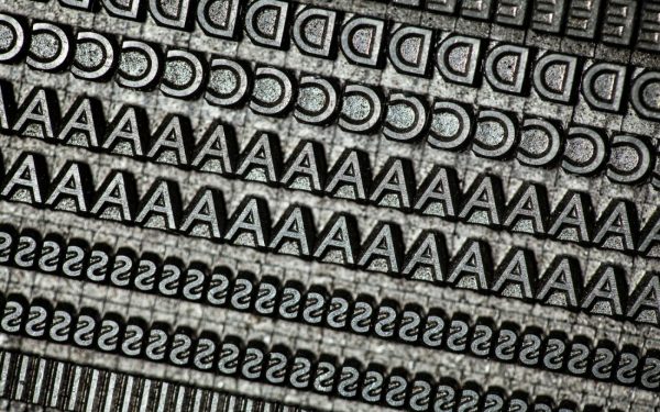 Close-up of metal letterpress type showing rows of letters D, A, and S.